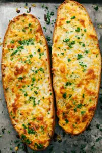 Two pieces of cheesy bread with green onions.