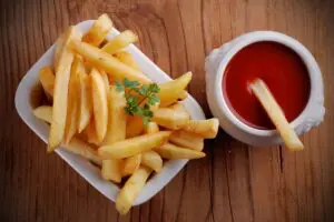 A bowl of french fries and ketchup on the table.