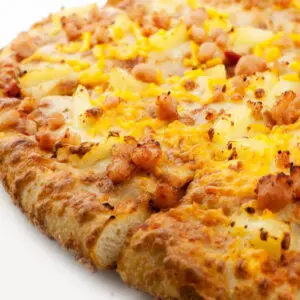 Close-up of cheesy pizza with bacon and pineapple.