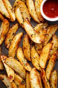 Crispy potato wedges with herbs and sauce.