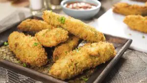 Fried jalapeno poppers on a wooden plate.