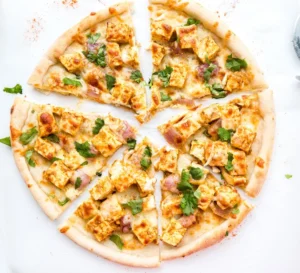 A closeup look at a Paneer Pizza with white background