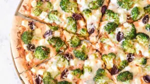 A closeup look at a broccoli pizza from the top