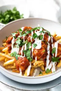 Chicken tikka masala fries with yogurt and cilantro.