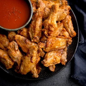 Fried chicken wings with dipping sauce.