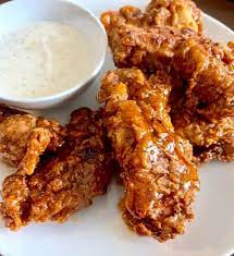 Crispy fried chicken tenders with dipping sauce.