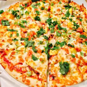 Cheesy pizza with toppings and cilantro.